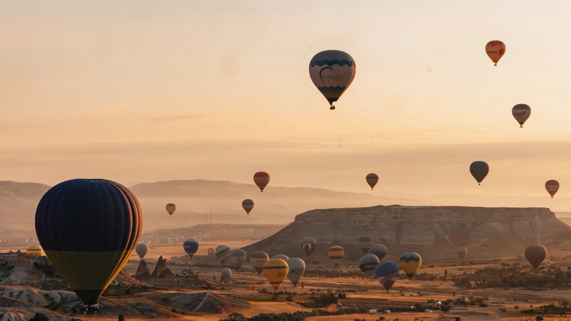 Hot-air balloons over Cappadocia’s valleys in warm morning light